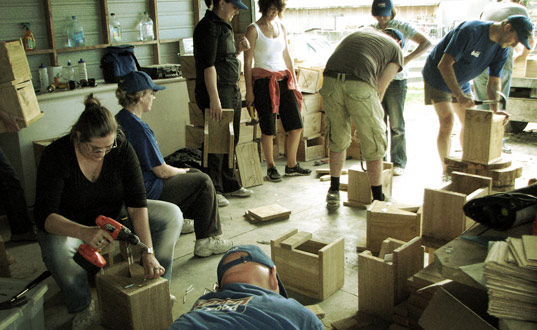 A group of volunteers making nesting boxes.